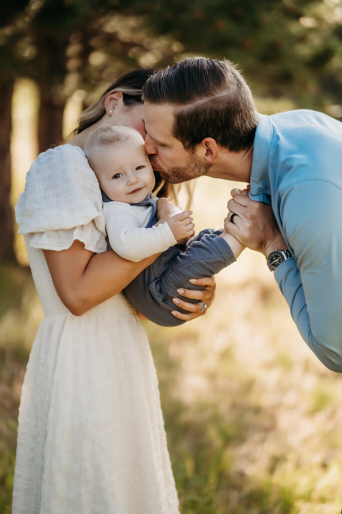 Denver Family Photographer captures father kissing baby's cheek during outdoor family photos