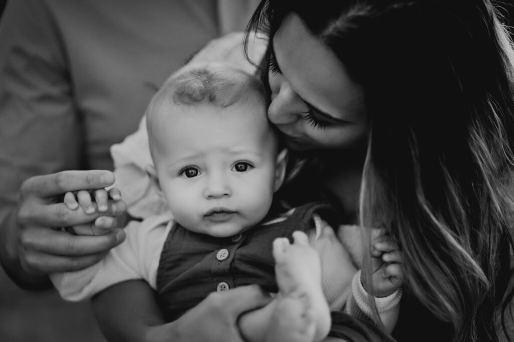 Denver Family Photographers capture mother holding baby and kissing his forehead