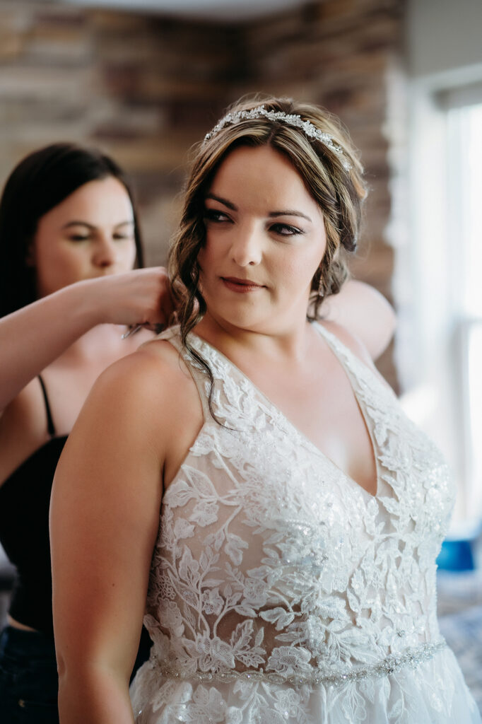 Colorado Elopement Photographer captures bride getting buttoned into dress