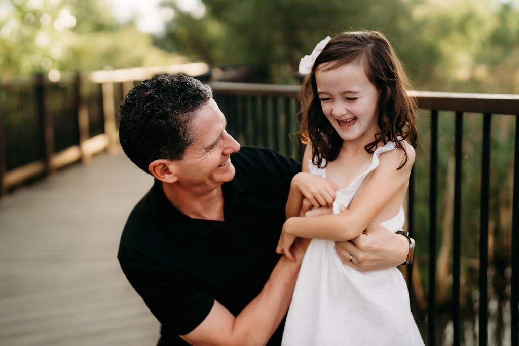 Denver Family Photographer captures dad playing with daughter and laughing together