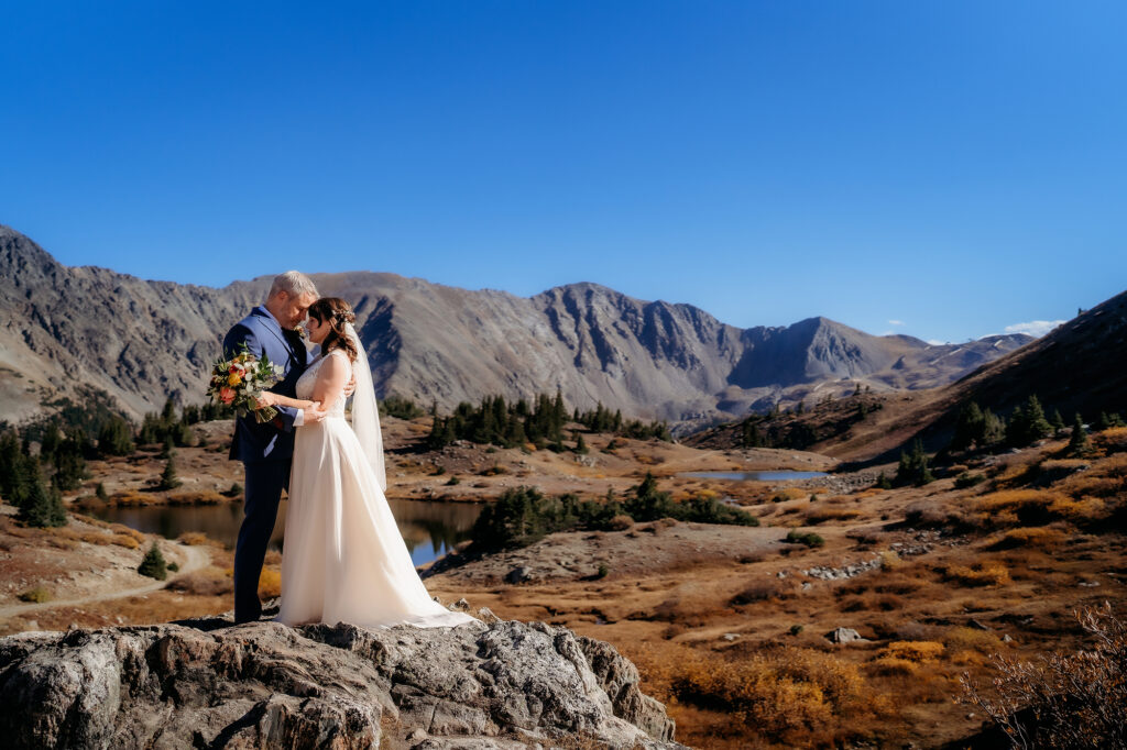 Colorado Elopement Photographer captures bride and groom kissing on boulder in Colorado adventure elopement