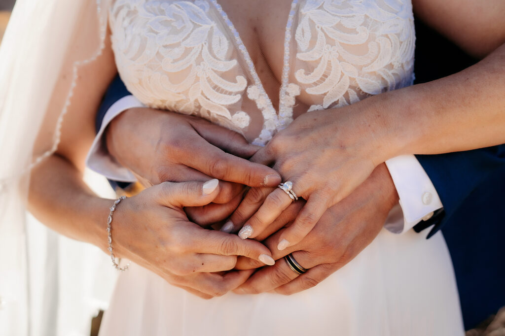 Colorado Elopement Photographer captures bride and groom holding hands focusing on wedding rings