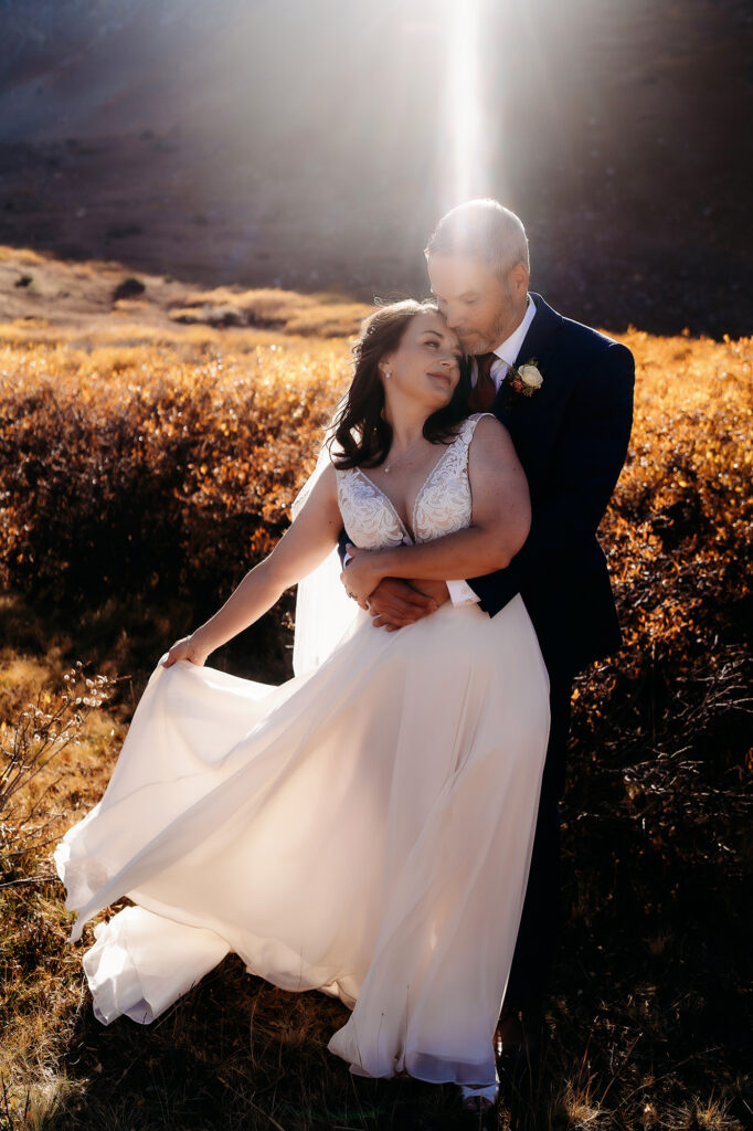 Colorado Elopement Photographer captures bride waving dress in wind