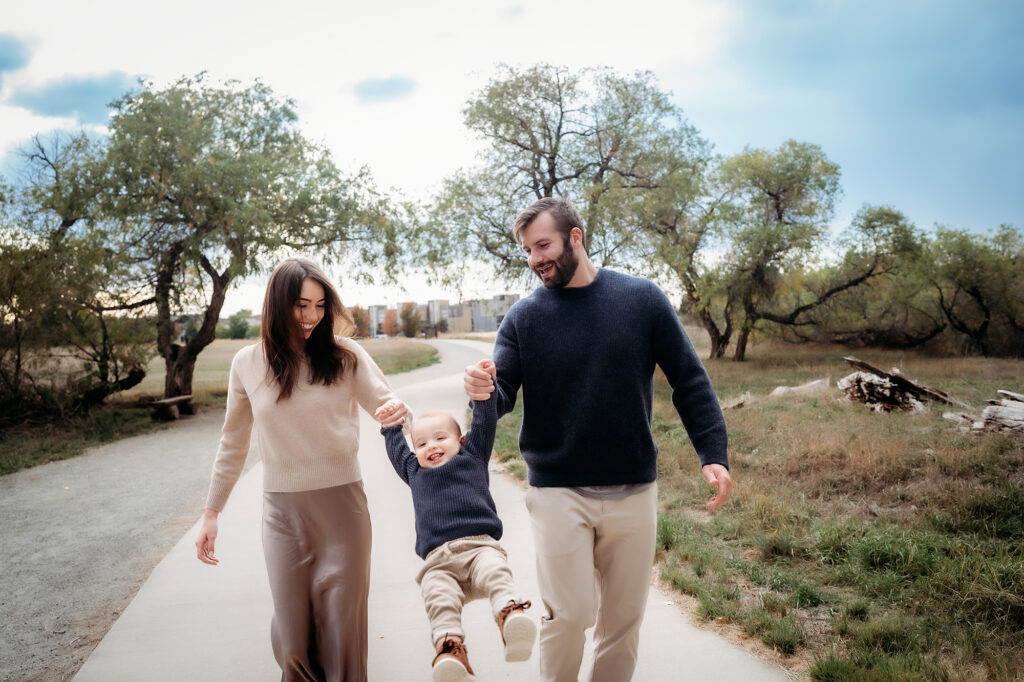 Denver Family Photographer captures mom and dad swinging baby in air