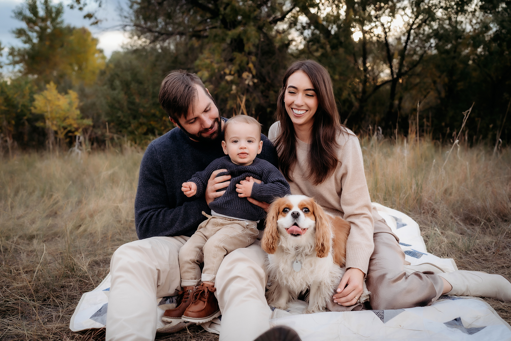 Denver Family Photographer captures young family sitting on blanket with family dog during outdoor family photo session