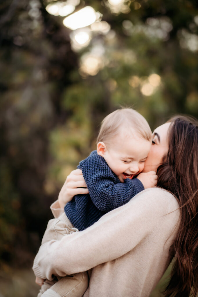 Denver Family Photographer captures mother hugging child and kissing his cheeks