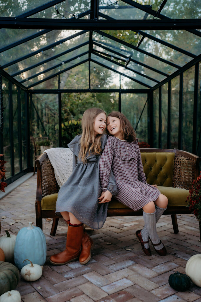 Denver Family Photographer captures sisters sitting back to back at greenhouse family photos