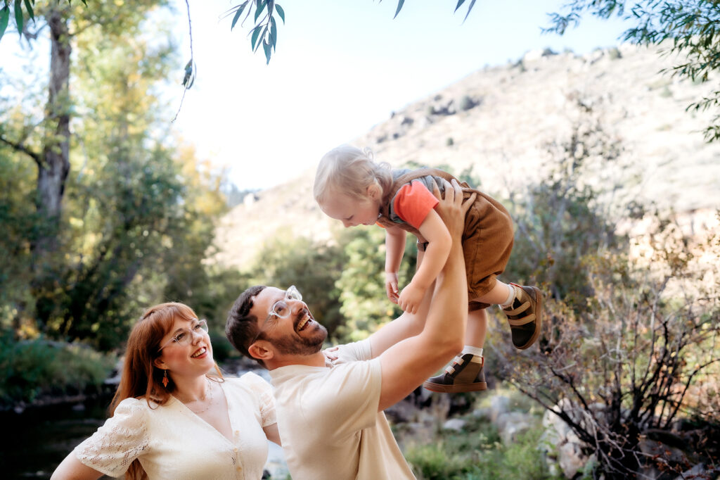 Denver Family Photographer captures father lifting baby in air and playing with him