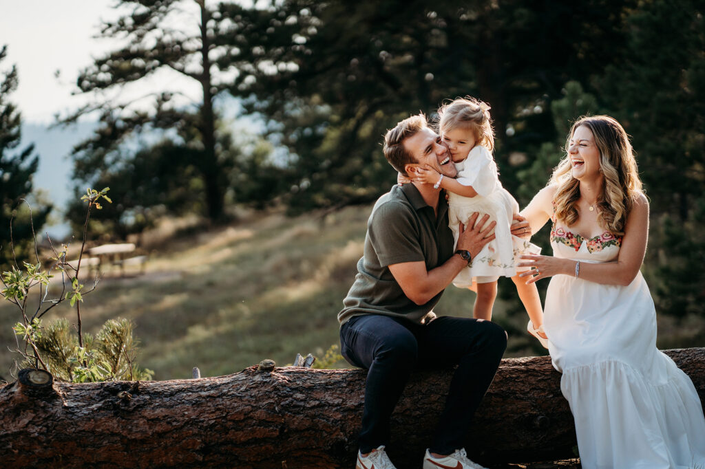 Denver Family Photographer captures daughter hugging father while standing on log