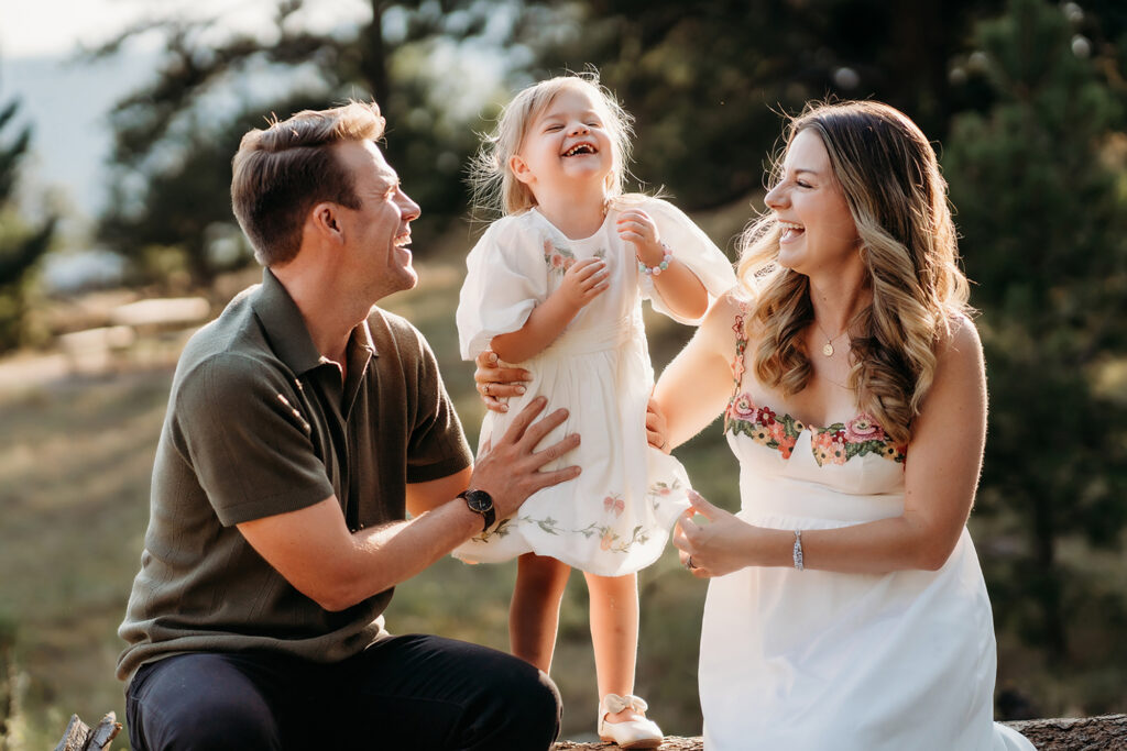 Denver Family Photographer captures young girl laughing with mom and dad during outdoor family photos