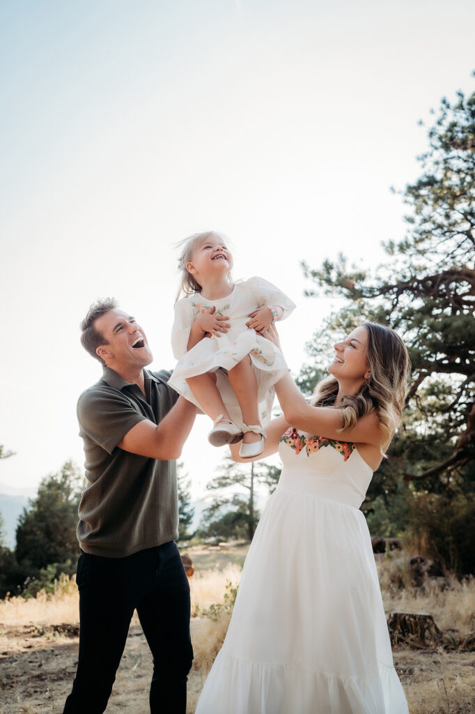 Denver Family Photographer captures mom and dad lifting baby in air