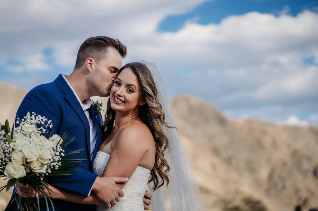 Colorado Elopement Photographer captures groom kissing bride's cheek after intimate elopement