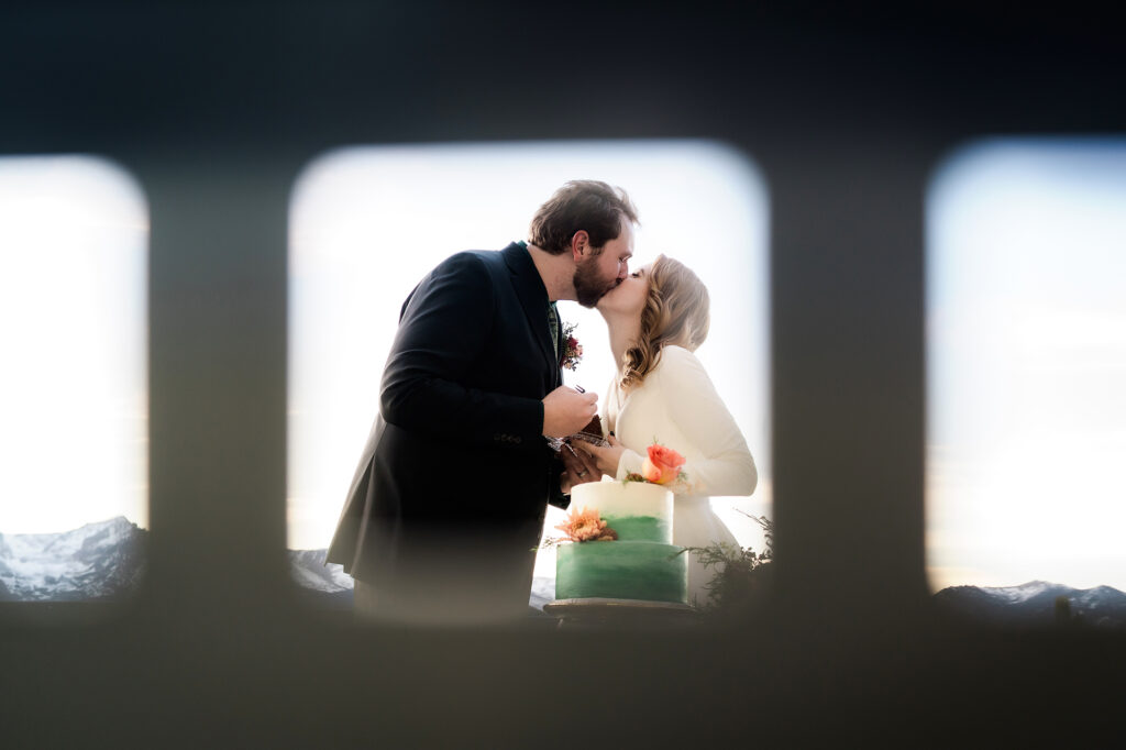 Colorado Elopement Photographer captures bride and groom cutting into cake after elopement