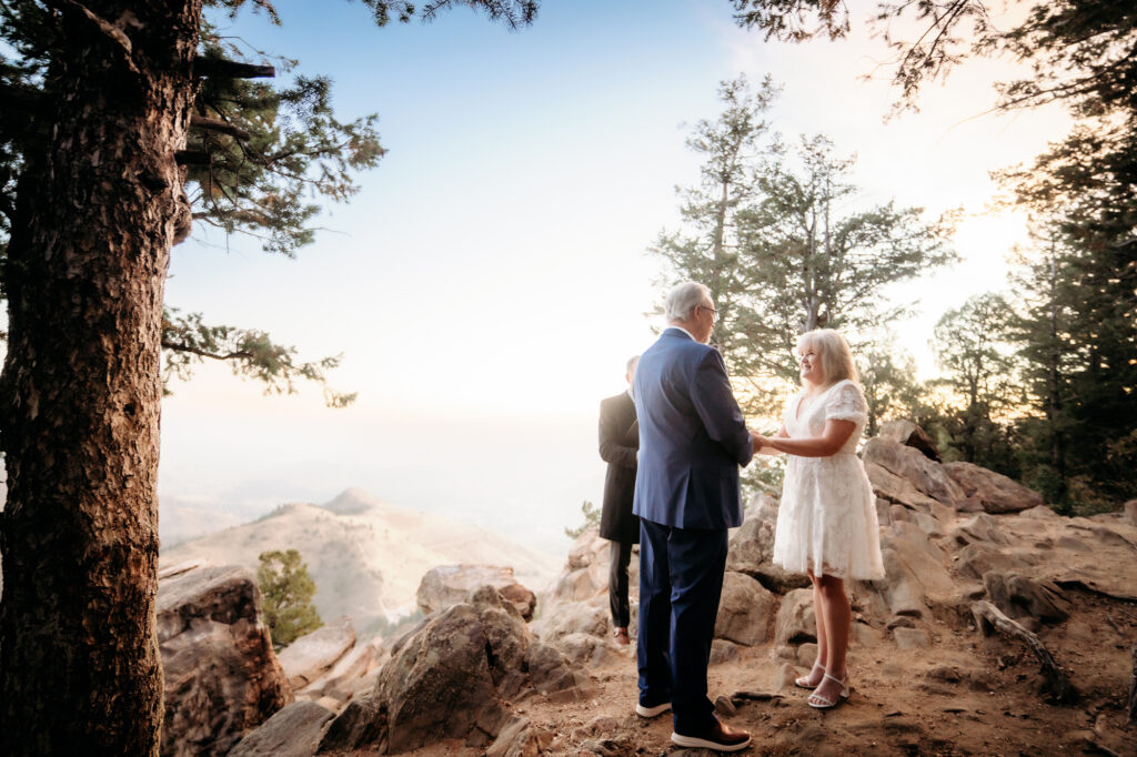 Colorado Elopement Photographer captures bride and groom holding hands during vow ceremony