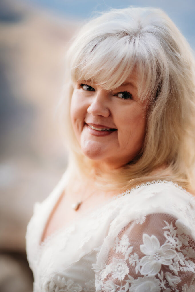 Colorado Elopement Photographer captures bride looking over shoulder and smiling at camera