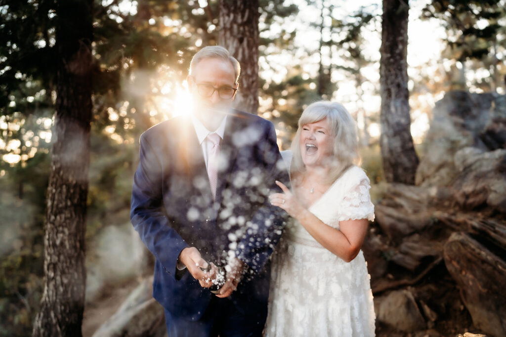 Colorado Elopement Photographer captures bride laughing as groom pops champagne