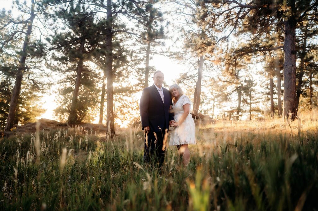 Colorado Elopement Photographer captures bride and groom standing in tall grass after Golden Colorado wedding