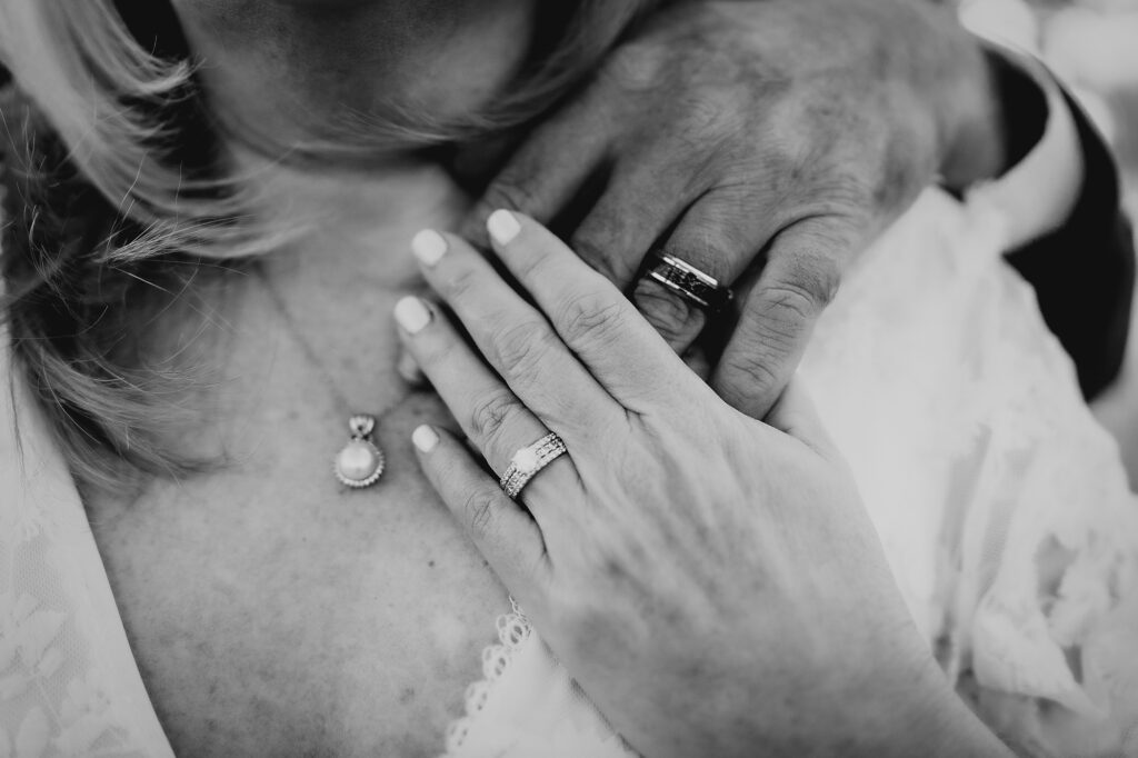 Colorado Elopement Photographer captures husband with hand on wife's shoulder showing wedding rings