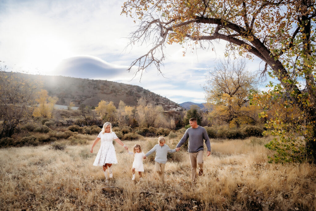 Denver Family Photographer captures family walking hand in hand through field of grass