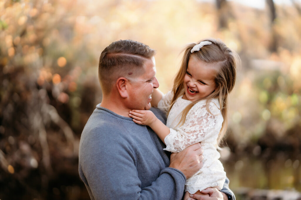 Denver Family Photographer captures father and daughter playing together during outdoor fall family photos in Denver