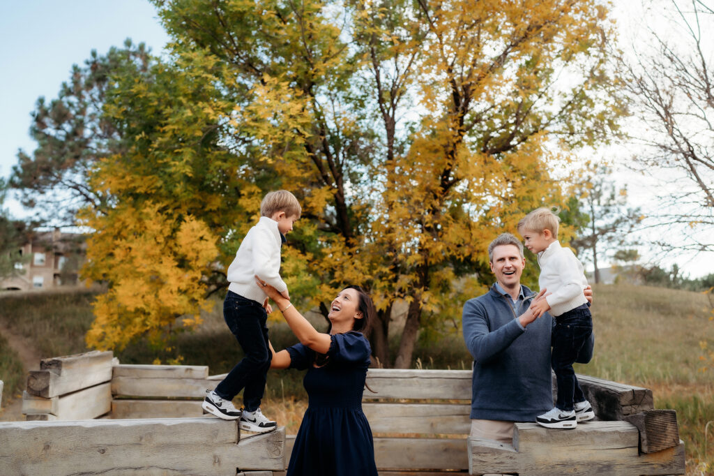 Denver Family Photographer captures parents lifting kids in air during outdoor family photos