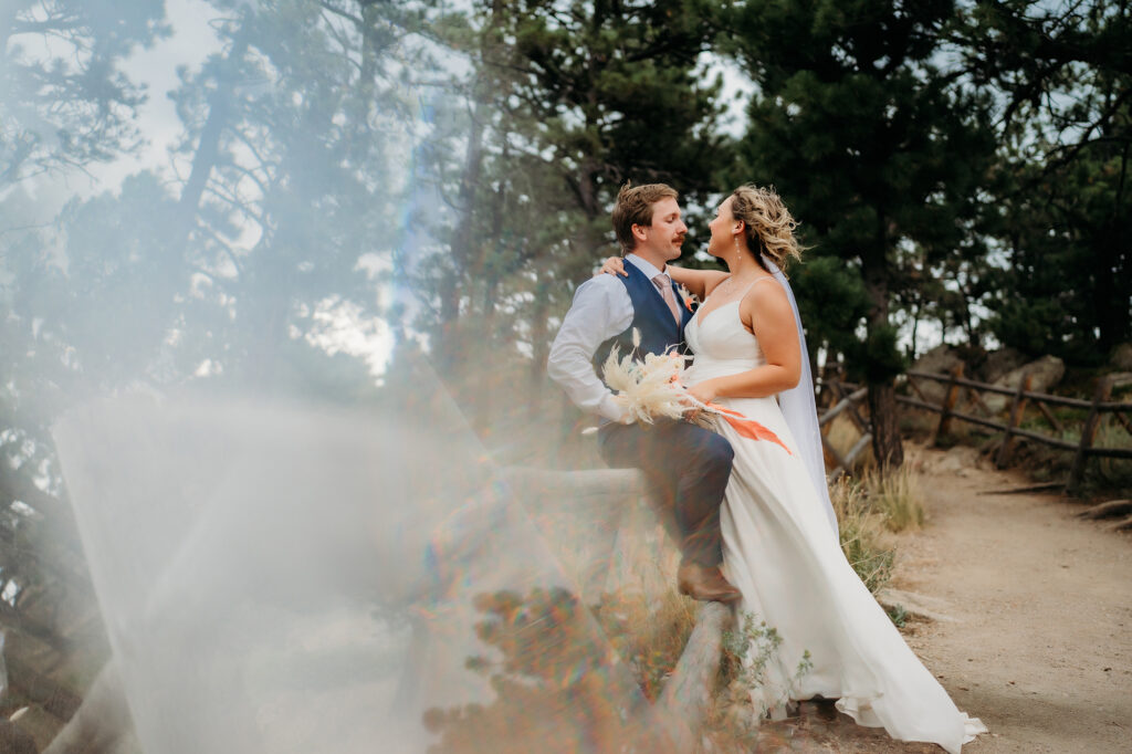 Colorado Elopement Photographer captures bride and groom leaning against fence during outdoor portraits after having a shot list to elevate your Colorado elopement