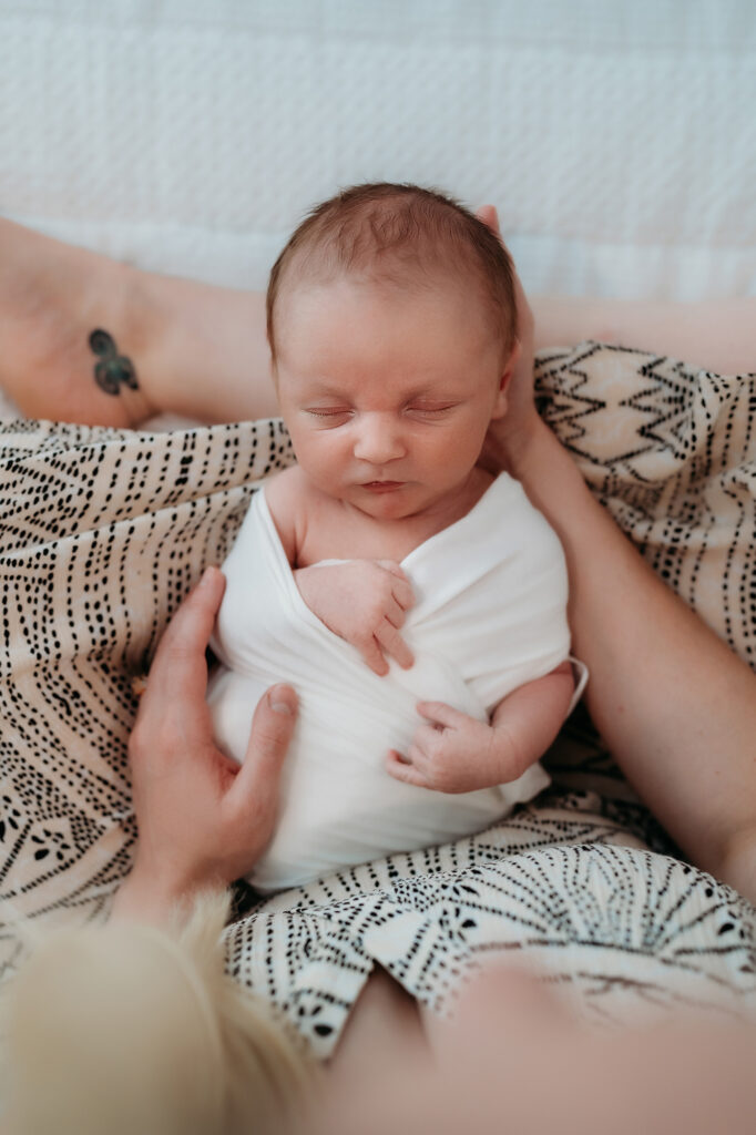 Denver Family Photographer captures baby in white swaddle during lifestyle family photo session