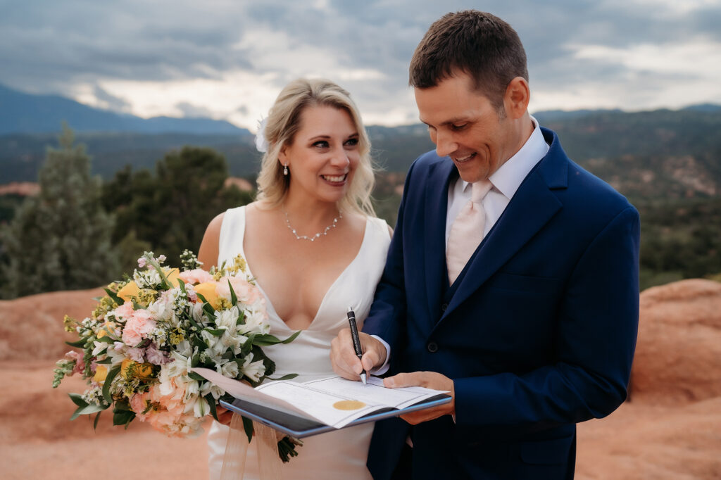 Colorado Elopement Photographer captures bride and groom signing marriage license
