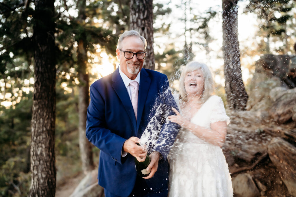 Colorado Elopement Photographer captures bride and groom popping champagne after Colorado elopement