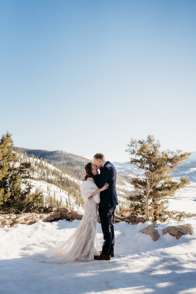 A first kiss as husband and wife in the snow-covered Colorado wilderness, celebrating the best day of your life.
