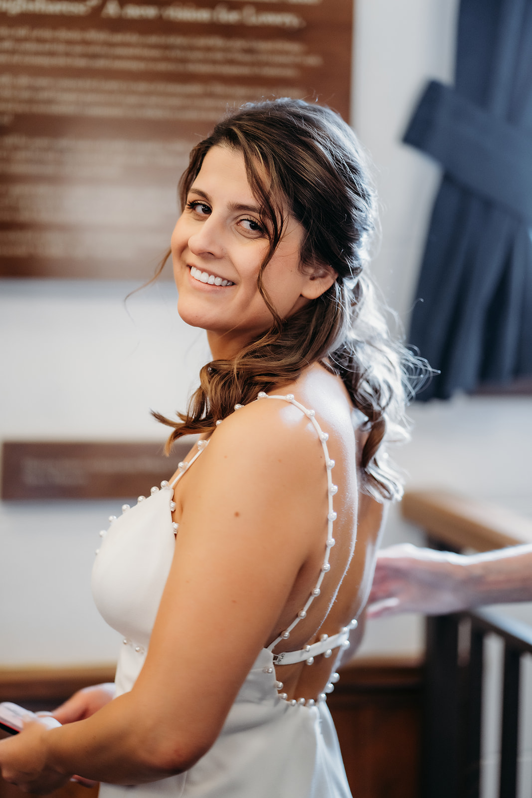 Bride smiling as she finishes getting ready at a historic Colorado chapel, moments before walking down the aisle.