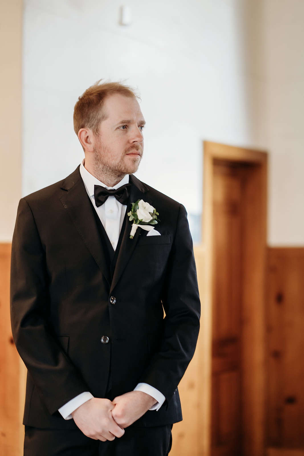 Groom waiting at the altar in Eisenhower Chapel, anticipation building before his small wedding in Colorado.