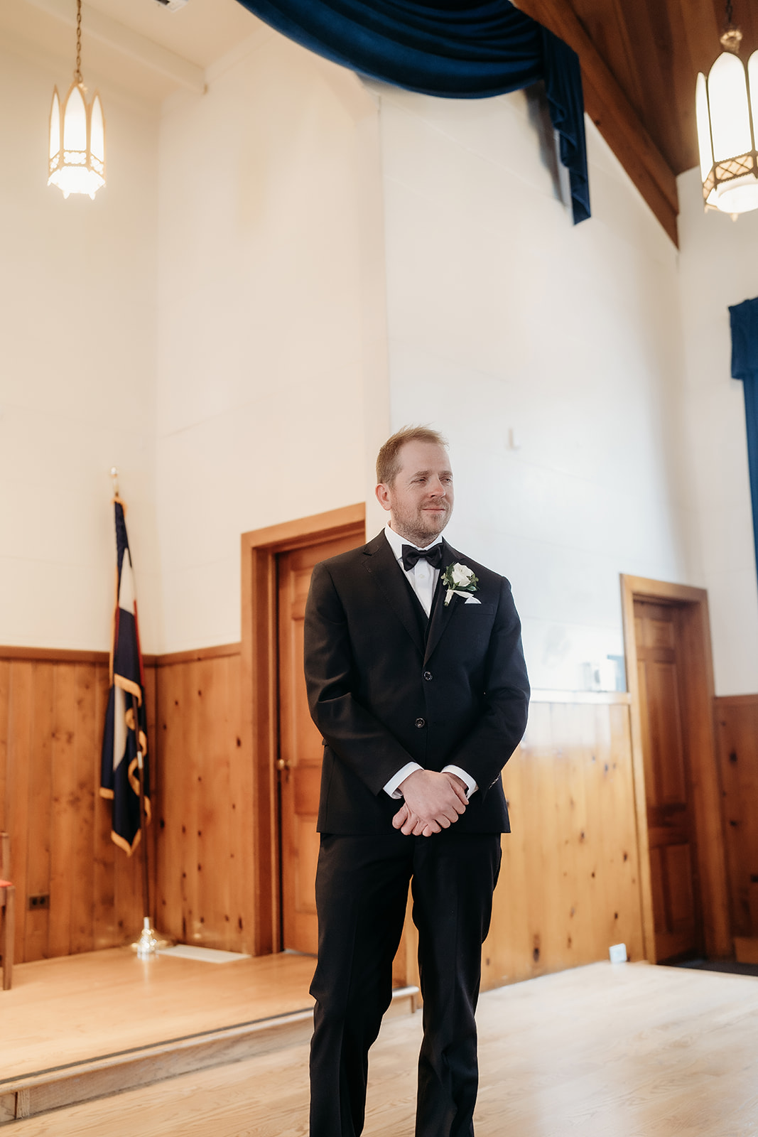 Full view of groom standing at the altar inside historic Eisenhower Chapel, ready for a heartfelt ceremony.