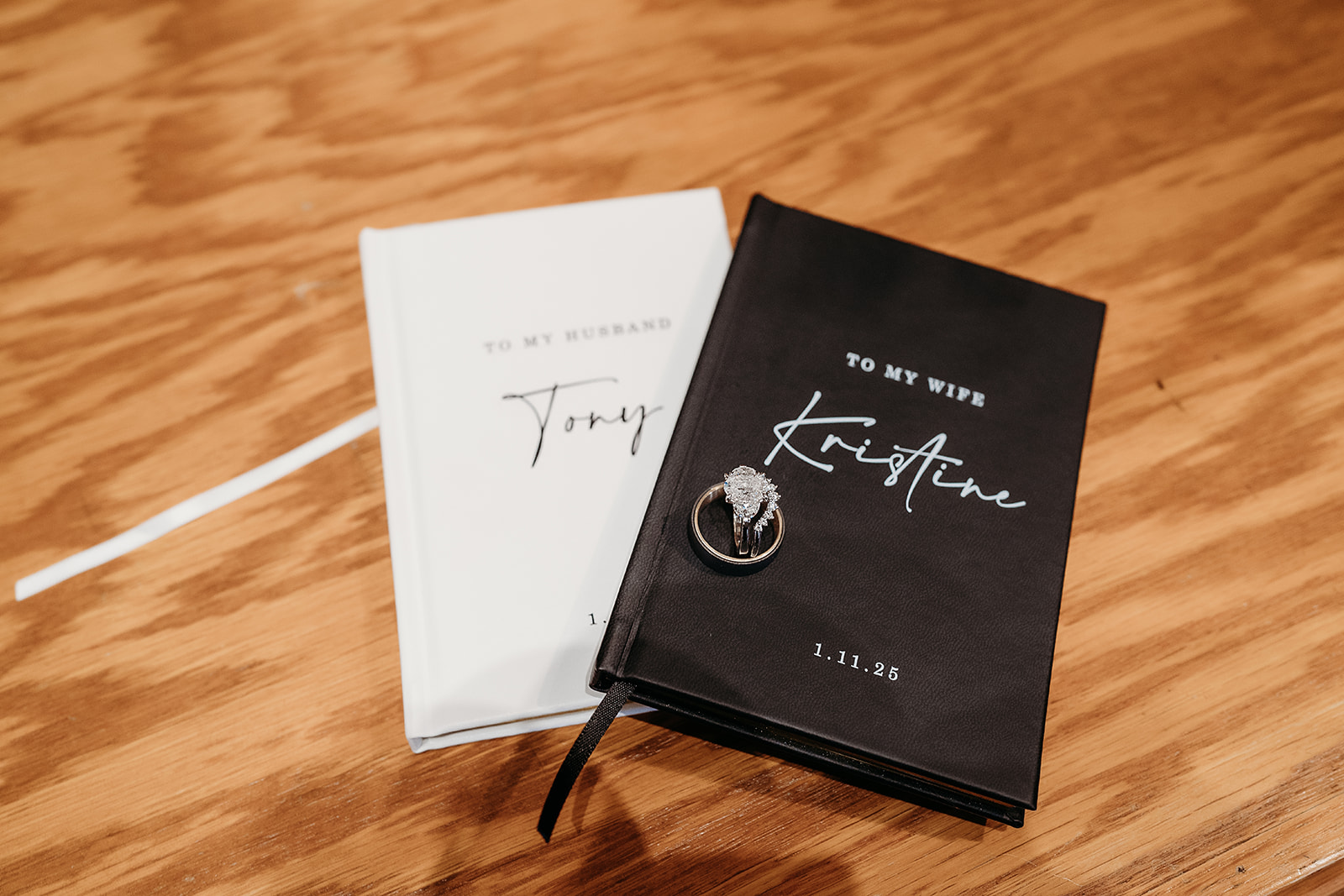 Wedding rings resting on personalized vow books, a meaningful detail from a small wedding in Colorado.