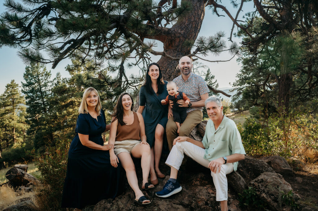 Denver Family Photographer captures family with grandparents sitting on rock during outdoor family photos