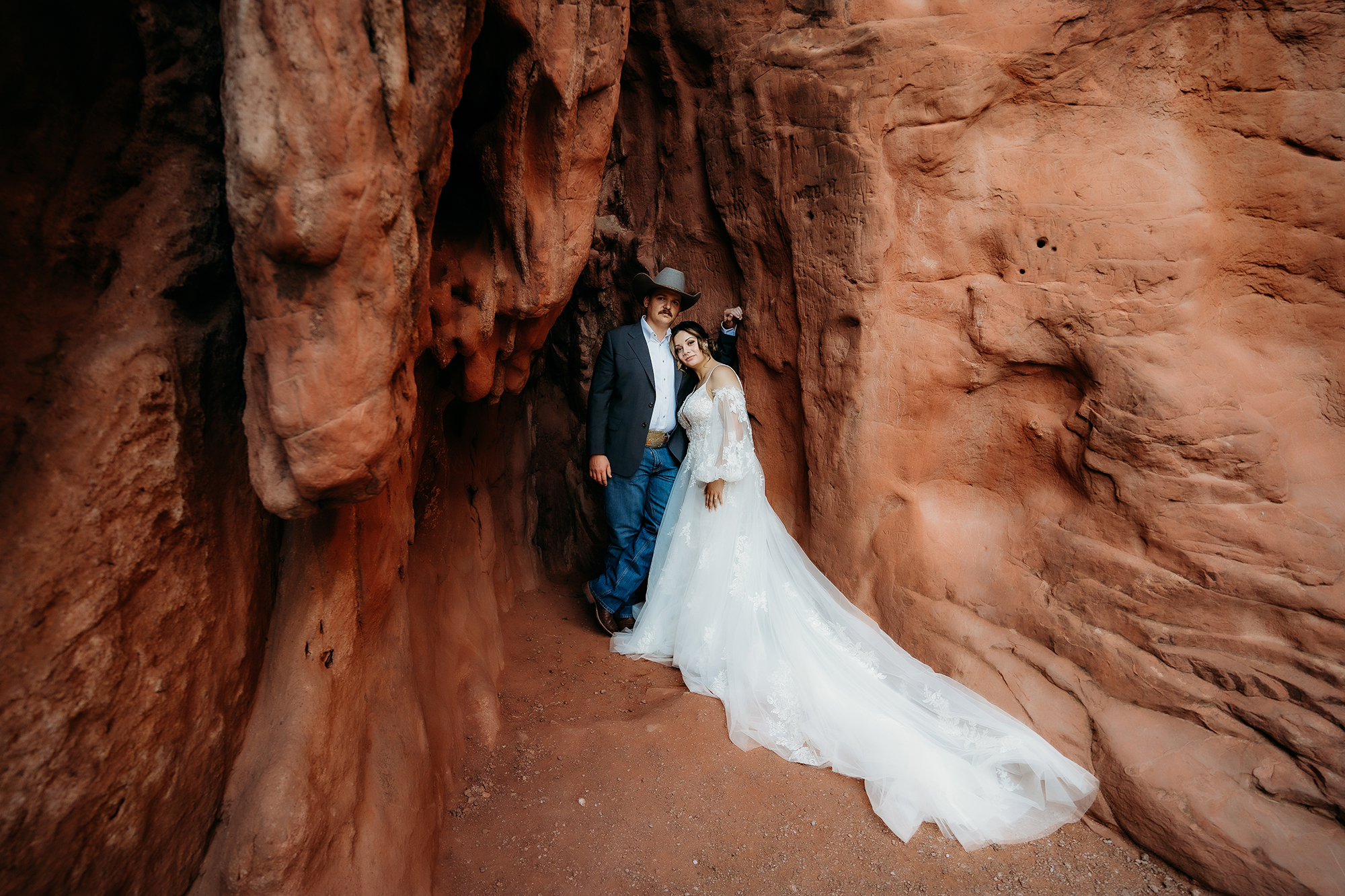 Bride and groom standing in red rock alcove after intimate Denver elopement
