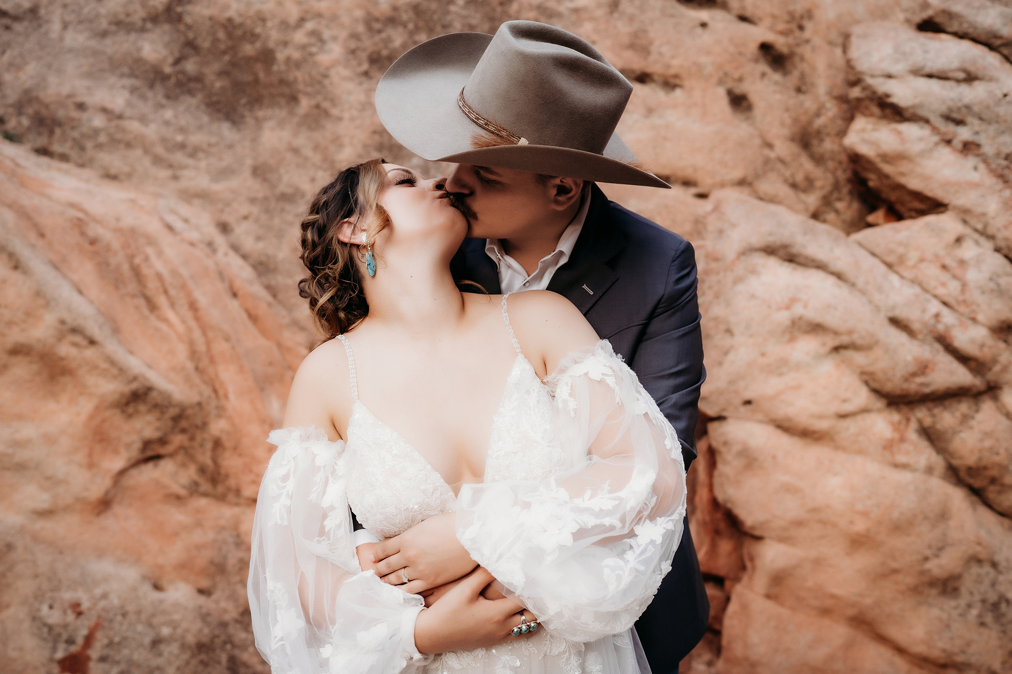 Bride and groom embracing with the groom kissing the bride’s cheek during an outdoor Denver elopement.