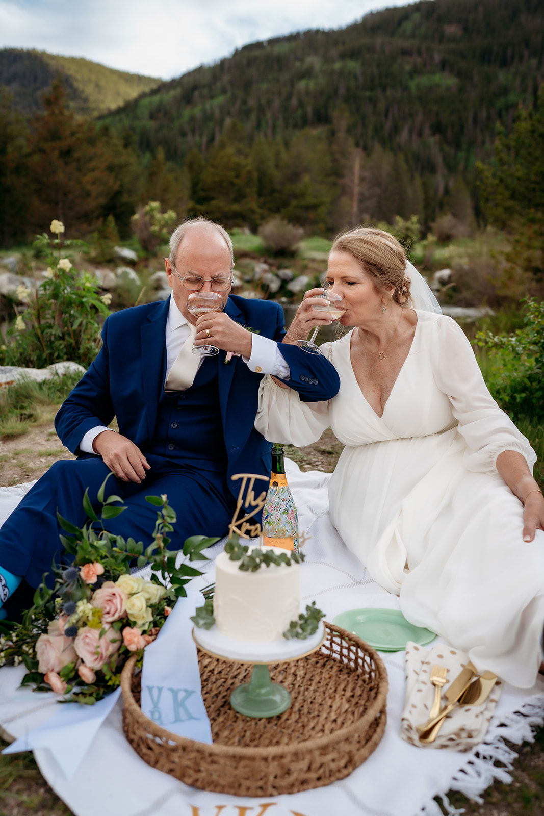 Sitting side by side, the newlyweds enjoy champagne outdoors—another beautiful example of How to Make Your Elopement Special with a personal toast.