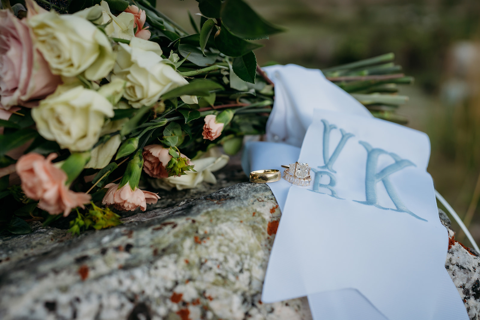 A close-up of elegant flowers, a ring, and a personalized ribbon—one idea for How to Make Your Elopement Special with meaningful details.