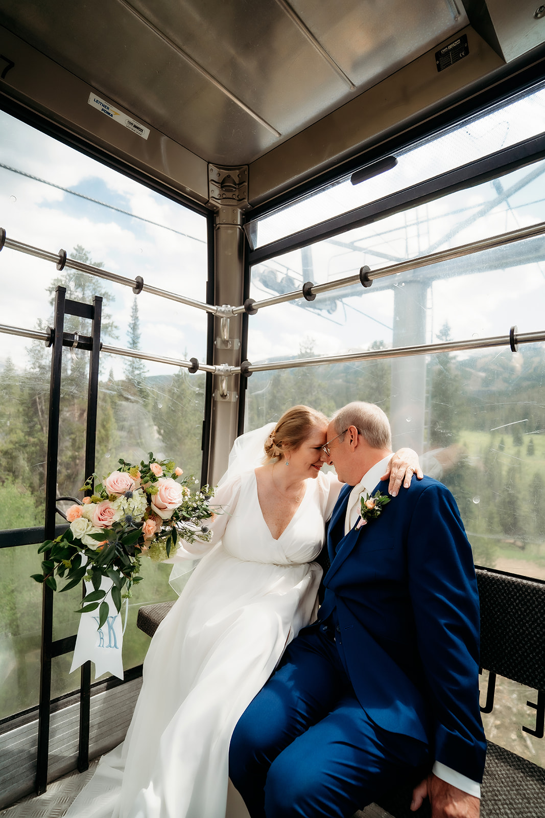The newlyweds cozy up inside a scenic gondola, bouquet resting beside them—a joyful and creative detail when planning How to Make Your Elopement Special.