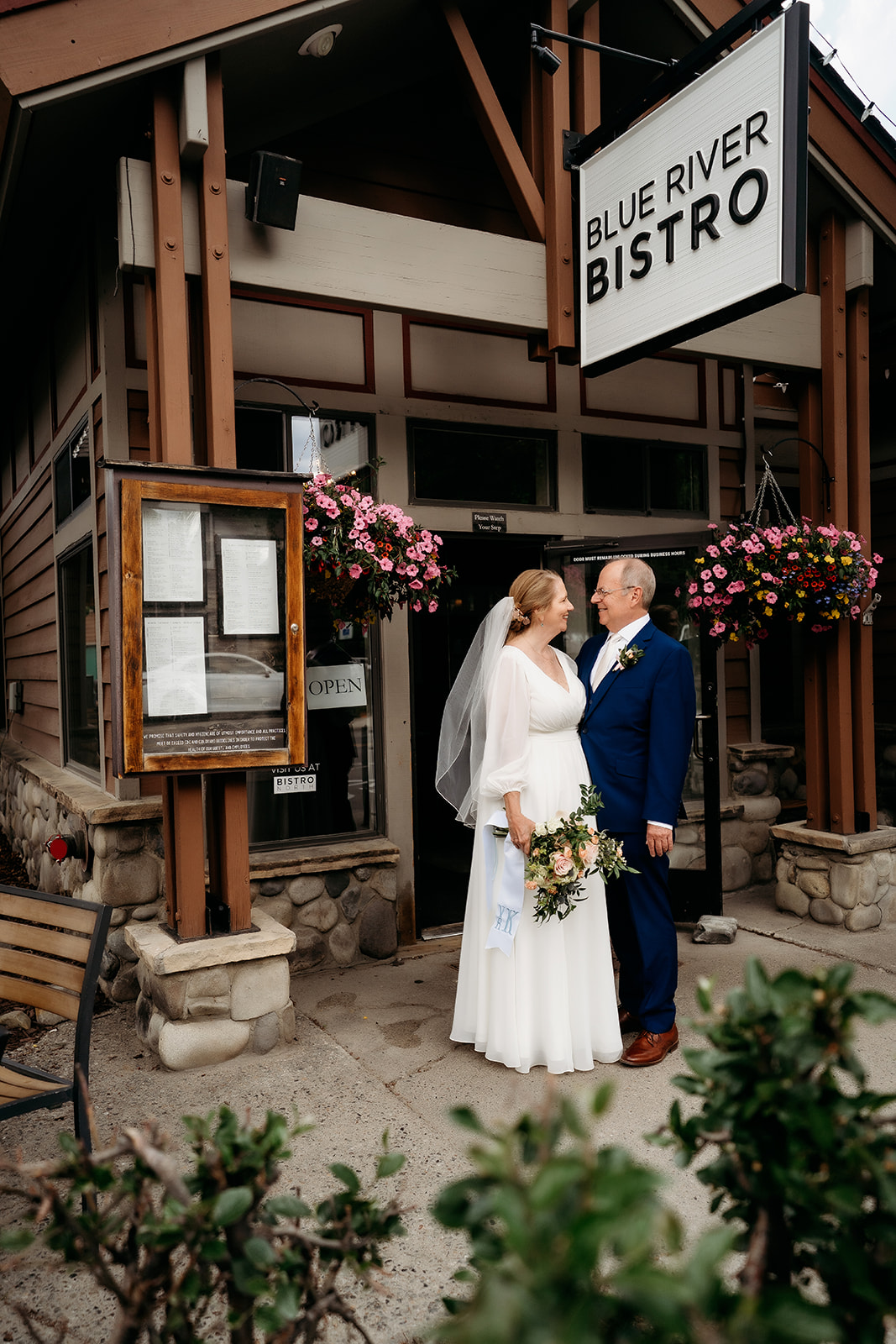 Newlyweds stand hand in hand outside the Blue River Bistro in downtown Breckenridge—a perfect example of How to Make Your Elopement Special by incorporating meaningful locations.