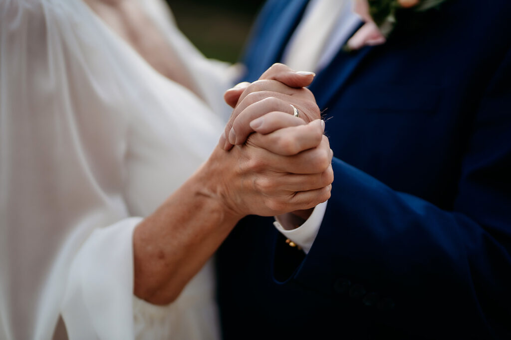 A detailed view of the couple's hands intertwined as they share a quiet, emotional first dance—showing How to Make Your Elopement Special with tender traditions.