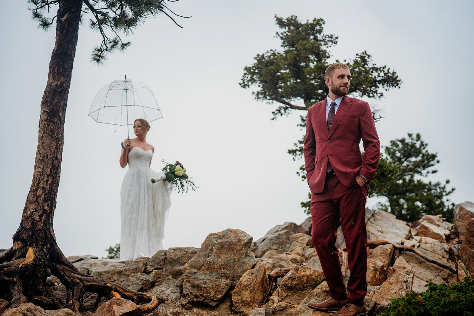 Couple standing hand in hand on a misty mountain peak, showing the adventurous spirit of how to plan an elopement.