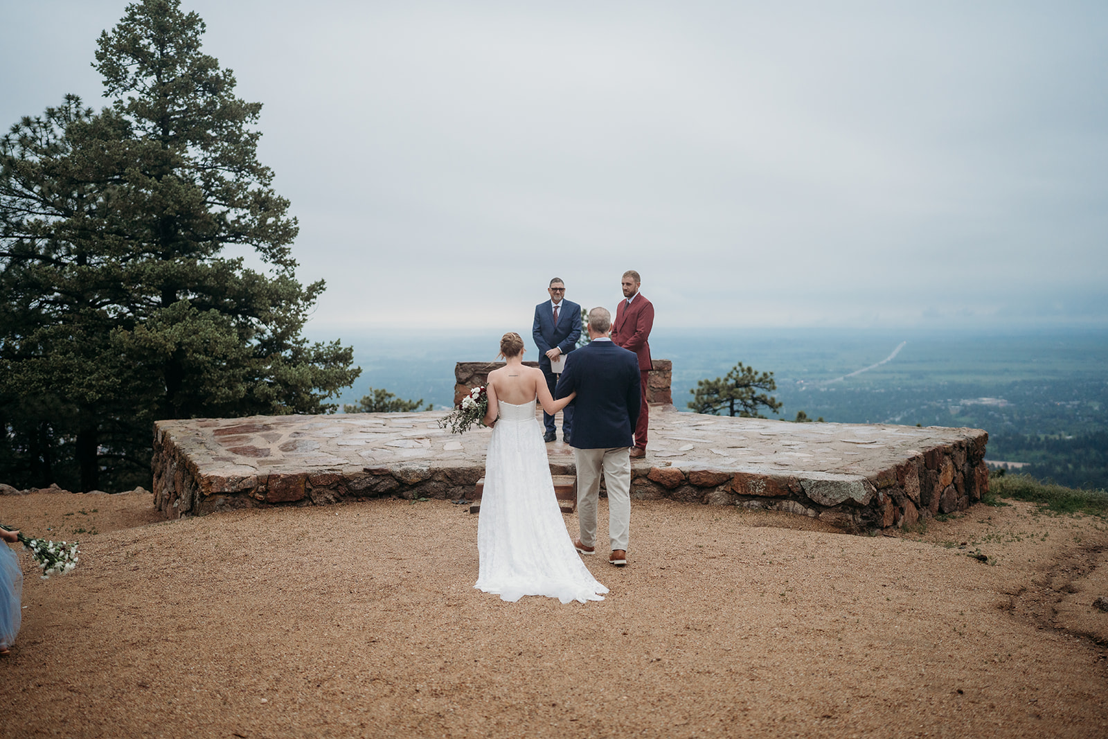 Bride walks down the aisle with her father at an outdoor mountain ceremony, a meaningful step in How to Plan an Elopement.