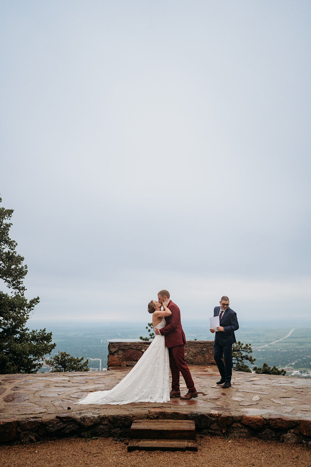 Couple shares their first kiss at the altar with mountains in the background, a highlight of How to Plan an Elopement.