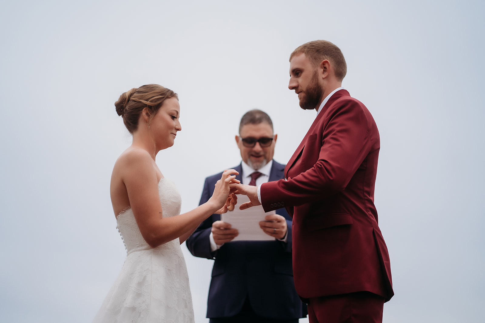 Bride places the ring on the groom’s finger during mountain ceremony vows.