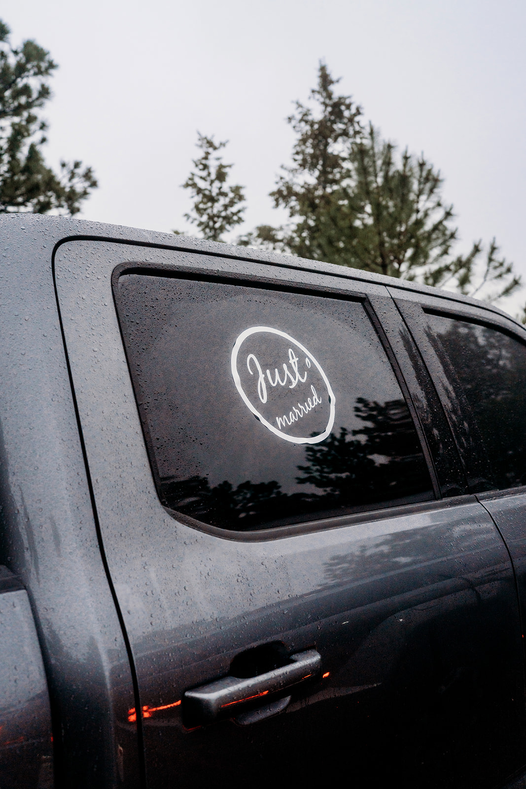 Truck window with a ‘Just Married’ decal, celebrating the couple’s mountain elopement.