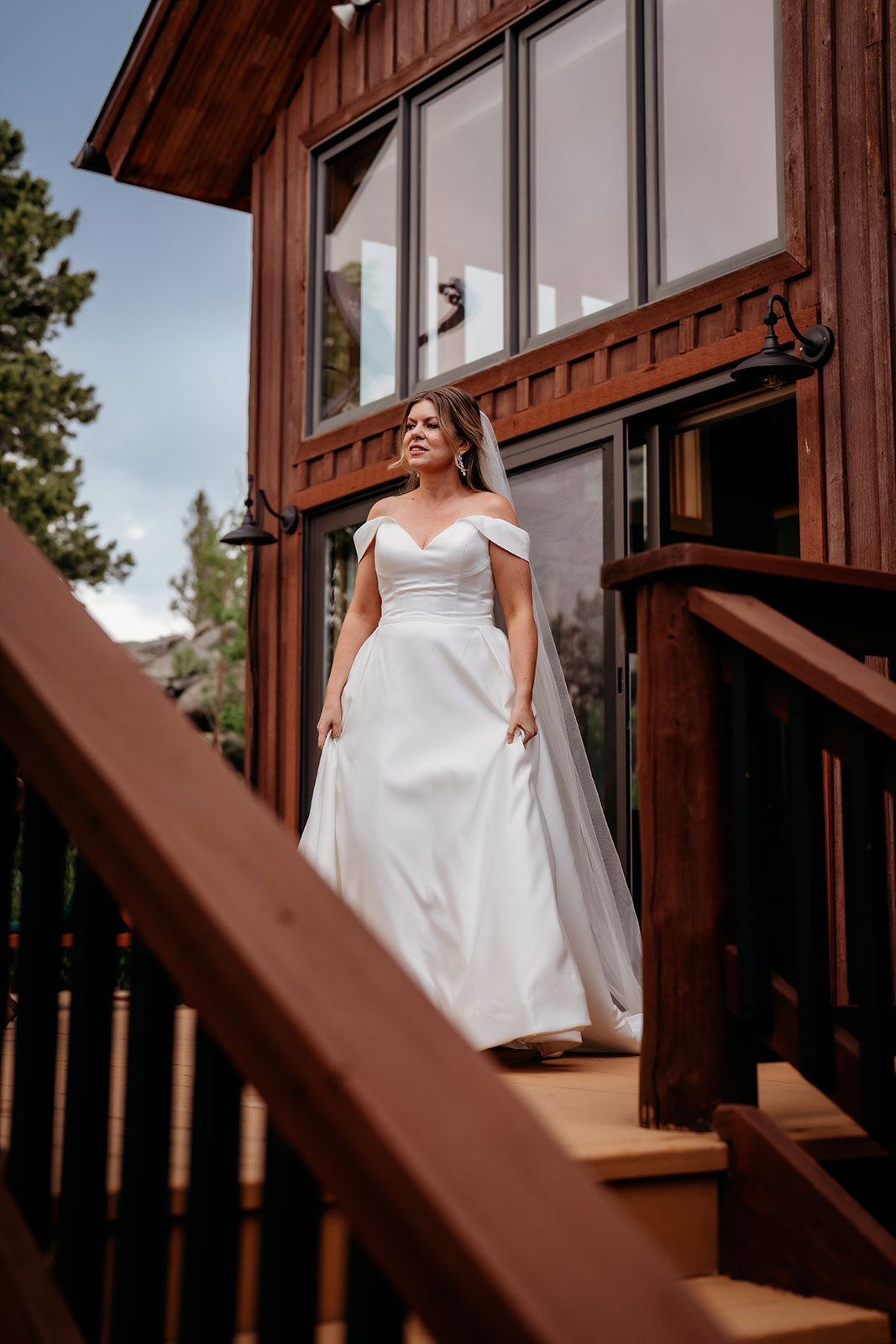 Bride walking down rustic cabin stairs in her wedding gown before her Colorado adventure elopement ceremony.