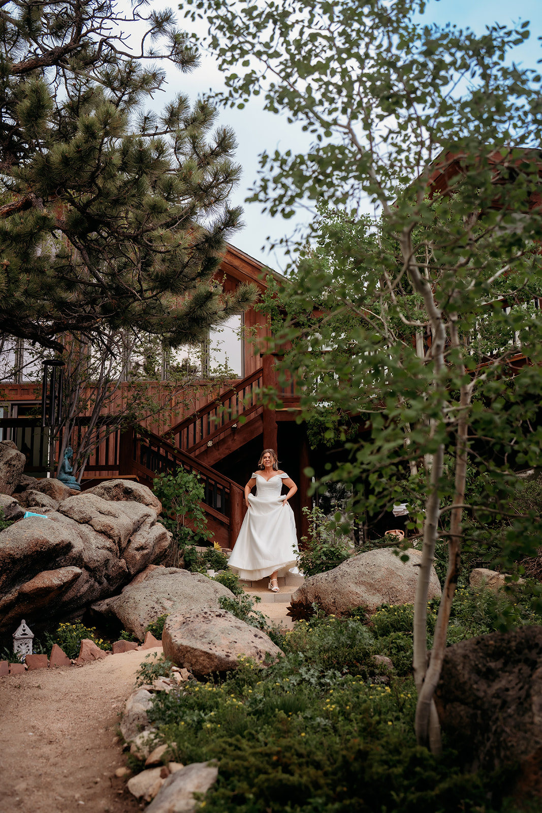 Bride walking along a rocky mountain path toward her Colorado adventure elopement ceremony.