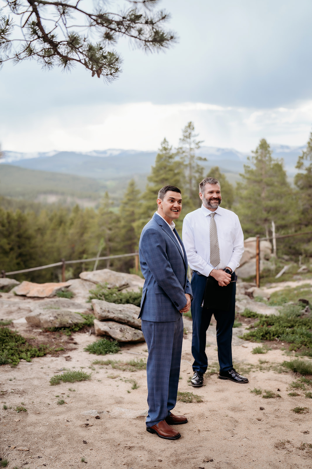Groom smiling with officiant while waiting for the bride at a Colorado adventure elopement.